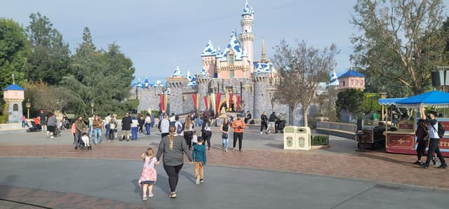 Family walking toward a theme park castle